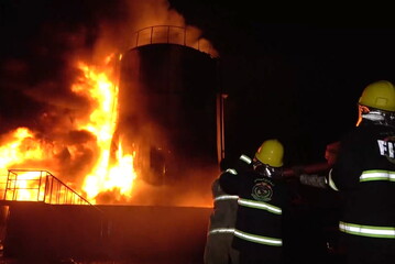 Firefighters extinguishing a fire at a cement factory following Israeli airstrikes