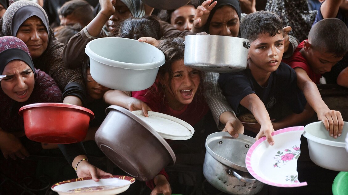 Gaza, famiglie palestinesi attendono pasti preparati da volontari