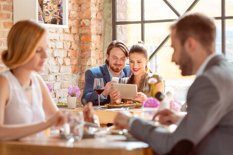 Una coppia usa un menu digitale al ristorante foto iStock.