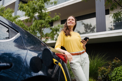 Una donna in attesa della ricarica della macchina elettrica , foto iStock.