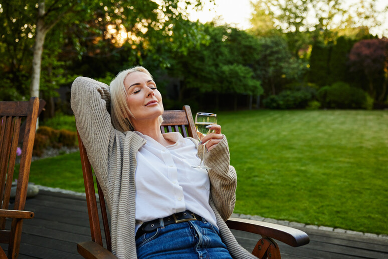 Una donna matura si gode il pomeriggio in terrazza foto iStock. - RIPRODUZIONE RISERVATA