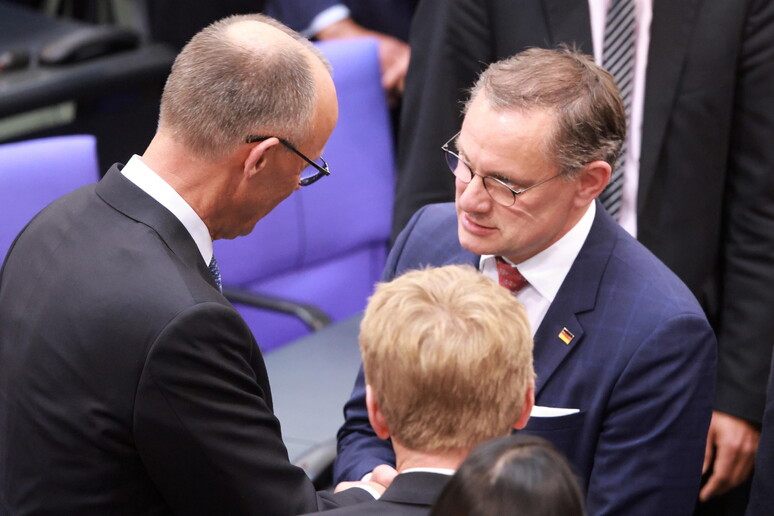 Alternative for Germany (AfD) party and faction co-chairman Tino Chrupalla (R) congratulates Merz © ANSA/EPA